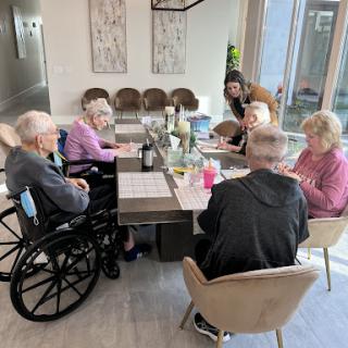 A group of seniors enjoying a social activity together in a bright and welcoming community space.