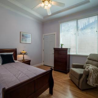 A cozy bedroom with a single bed, ceiling fan, and natural light from the window.