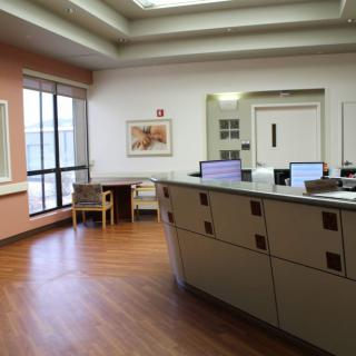 A hospital reception area with a desk, computers, and seating.