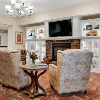Cozy living room with comfortable armchairs, a fireplace, and a television.