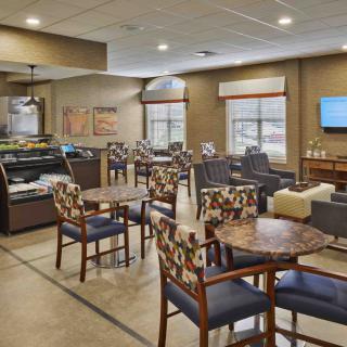 A modern cafe interior with tables and chairs arranged in a cozy seating area.