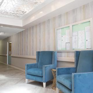 A stylish and modern lobby featuring blue upholstered chairs and elegant wall decor.