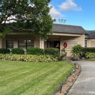 A suburban house with a well-maintained lawn and driveway on a clear day.
