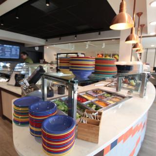 A modern restaurant interior with colorful bowls on a food counter.