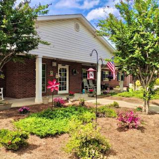 A charming residential home with a beautiful garden and inviting porch.