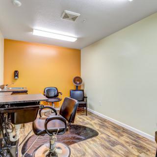 A well-lit hair salon with stylish chairs and mirrors, featuring vibrant wall colors.