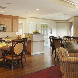 Open concept living and dining area with a kitchen in the background.