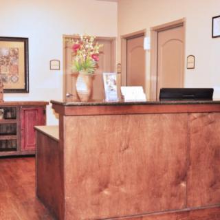 A well-organized reception area featuring a wooden desk and decor elements.