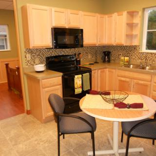 A cozy kitchen featuring modern appliances and a small dining area.