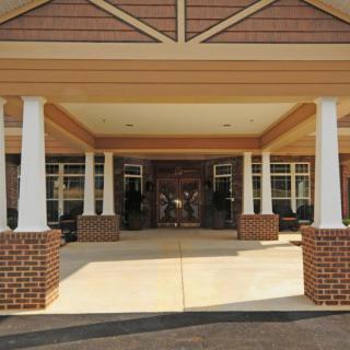 Front entrance of a building with columns and brickwork.