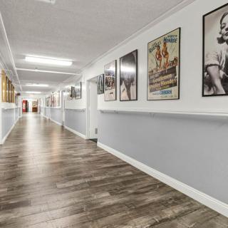 A long hallway adorned with framed posters and modern wooden flooring.