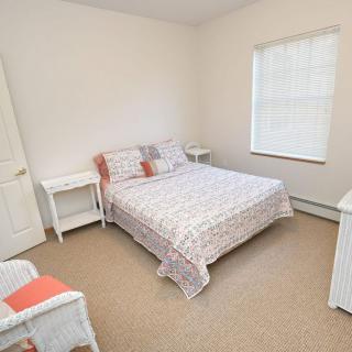 A simple bedroom with a double bed, two nightstands, and a window.