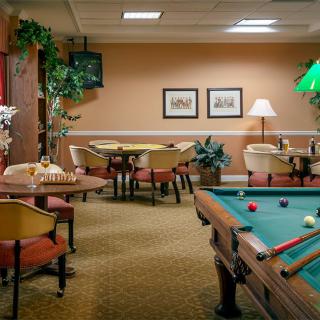 A cozy game room with a pool table and seating area.