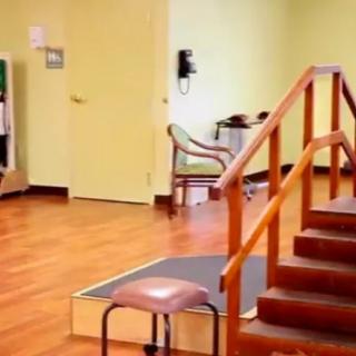 A physical therapy room featuring exercise equipment and stairs for rehabilitation exercises.