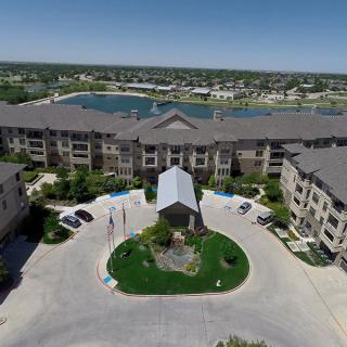 Aerial view of a residential apartment complex with a nearby lake.