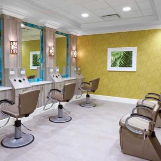 A modern and stylish hair salon interior with multiple styling stations and comfortable chairs.