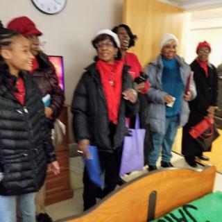 A cheerful group of friends enjoying a social gathering indoors, dressed in warm winter clothing.