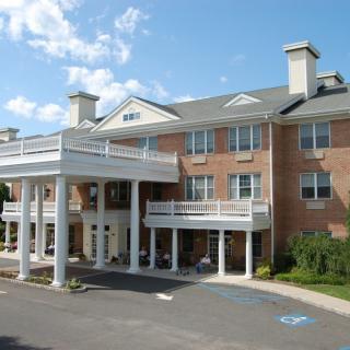 A modern senior living facility with a welcoming entrance and classic architectural design.