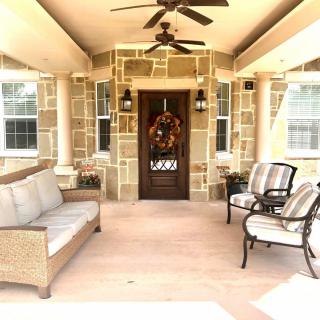 A cozy porch with wicker furniture and a decorative wreath on the front door.