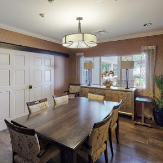 A stylish and cozy dining room featuring a wooden table, elegant chairs, and natural light.