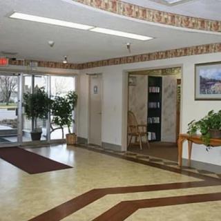 A spacious lobby with an elevator and decorative plants.