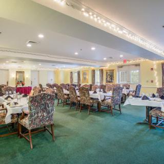 A spacious dining room with elegantly arranged tables and comfortable seating.