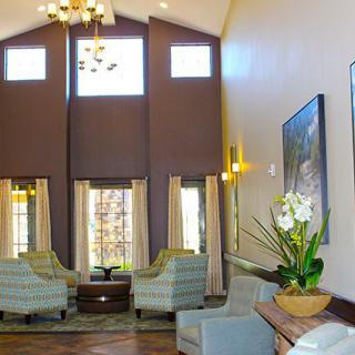 A spacious lobby with high ceilings, modern furniture, and large windows allowing plenty of natural light.