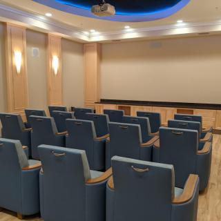 A cozy home theater setup with plush seating and a large projector screen.