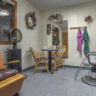 Cozy hair salon interior with chairs, a table, and salon equipment.