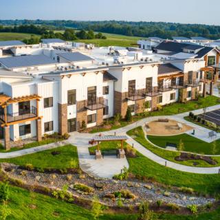 A modern apartment complex with landscaped gardens and outdoor spaces.