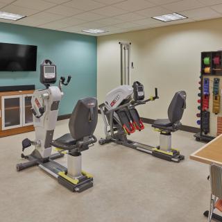 A small gym with stationary exercise bikes and weights, designed for indoor fitness routines.