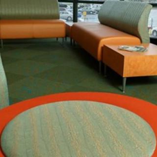 A modern seating area with orange and gray furniture in a lobby.