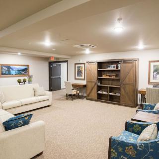 A cozy living room with sofas, shelves, and warm lighting.