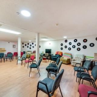 A meeting room with an eclectic decor featuring vinyl records on the walls and various chairs arranged in a semi-circle.