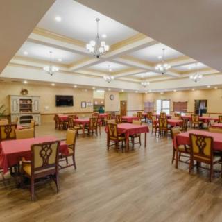 Spacious dining area with elegantly set tables and chandeliers.