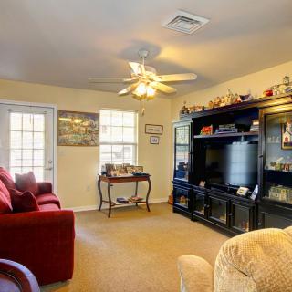 Cozy living room with a television, sofa, and ceiling fan.