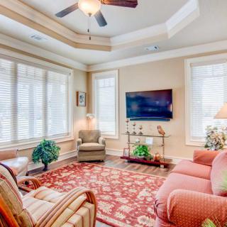A cozy living room with elegant furniture, a large rug, and ample natural light.