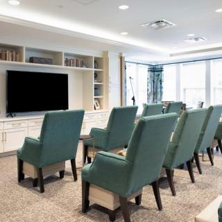 A well-organized seating area facing a large television, resembling a small conference room or home theater.