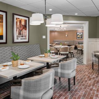 A modern dining area featuring stylish furniture, elegant lighting, and decorative wall art.