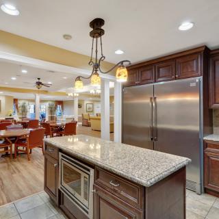 A spacious, modern kitchen with a granite island, stainless steel appliances, and an open-concept dining area.