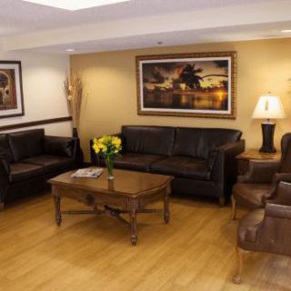 A cozy living room with leather sofas and a wooden coffee table, adorned with artwork and ambient lighting.
