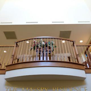 A spacious interior featuring a beautifully designed balcony with wooden railings and decorative plants.