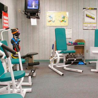 A small indoor gym with various exercise equipment and weights.