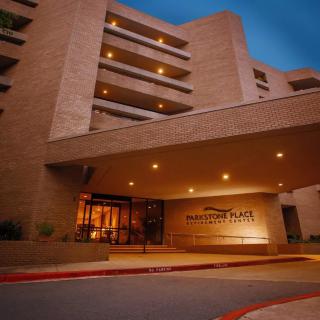 A nighttime view of a hotel's main entrance with warm lighting.
