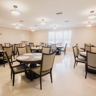 An empty dining room with neatly arranged tables and chairs.