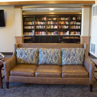 A cozy living room setup featuring a comfortable sofa and a bookshelf filled with books.