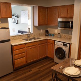 A cozy kitchen with wooden cabinets, modern appliances, and a small dining area.