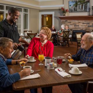 A group of seniors enjoying breakfast and coffee in a cozy restaurant setting.