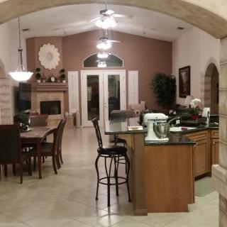 A modern open floor plan kitchen and dining area with elegant furnishings and appliances.
