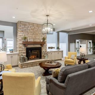 A cozy living room with a central fireplace, comfortable seating, and stylish decor.